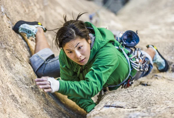 坚持这种悬崖的女性登山者. — 图库照片