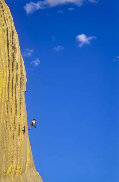 Skalní lezec rappells. — Stock fotografie