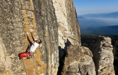 Climber clinging to a cliff. clipart