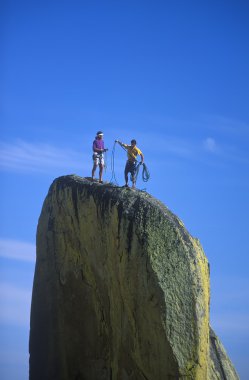 Climber dangling from the edge. clipart