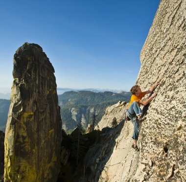 Rock climber reaching. clipart