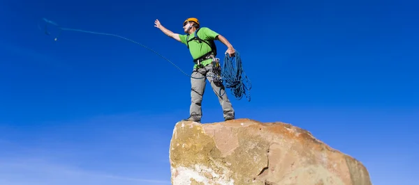 Bergsteiger seilt sich vom Gipfel ab. — Stockfoto