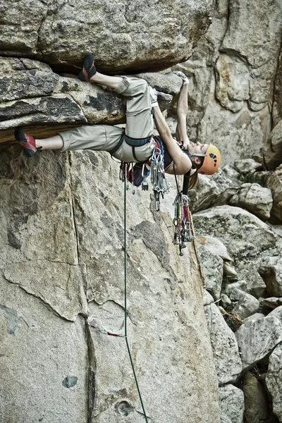 Escalador de rocha agarrado a um penhasco íngreme . — Fotografia de Stock
