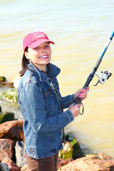 La giovane donna sulla pesca Foto Stock Royalty Free
