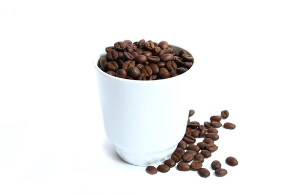 Kaffebönor i en kopp på en vit bakgrund — Stockfoto