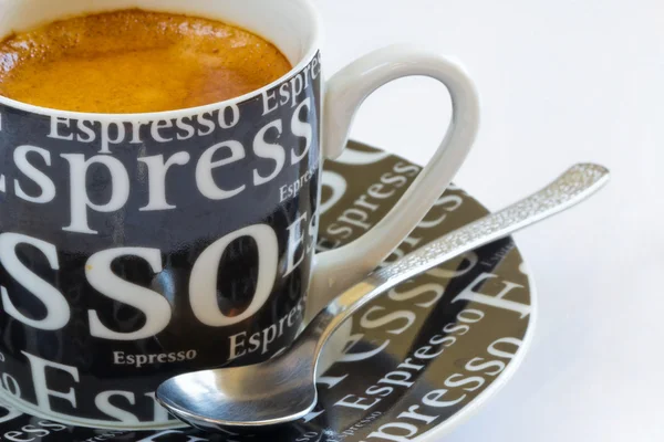 Свіжа кава еспресо з кавою в чорній чашці з ложкою — стокове фото