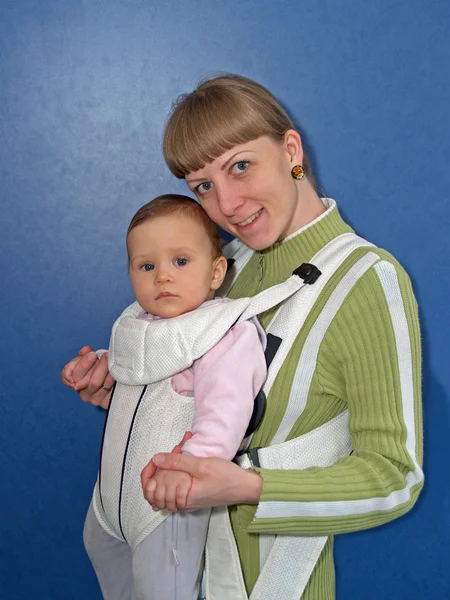 A mulher mantém o bebê em uma funda de bebê — Fotografia de Stock