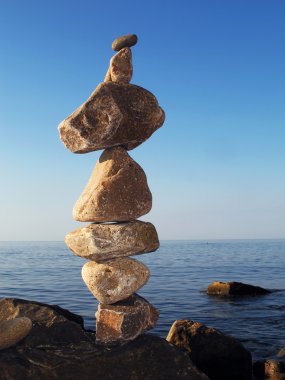 Cairn on blue sky background. clipart