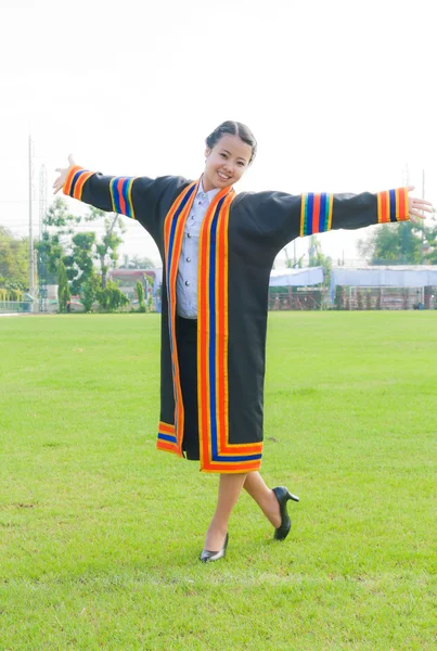 Выпускница азиатской школы на травяном поле — стоковое фото