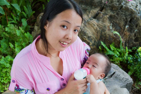 Mulher asiática alimentando seu bebê e sorriso — Fotografia de Stock