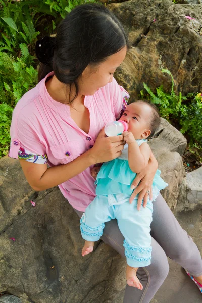 Asian woman feeding her baby top vertical — Stock Photo, Image