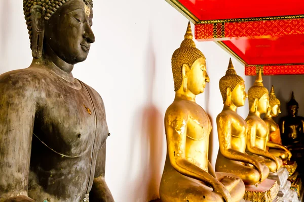Svart buddha staty bland andra golden — Stockfoto