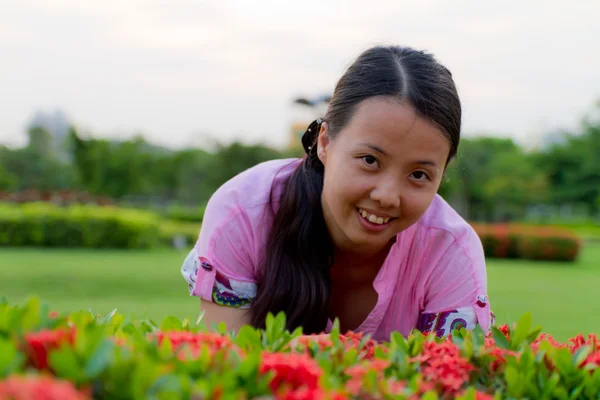 Asiatico donna sorridente oltre verde pianta — Foto Stock