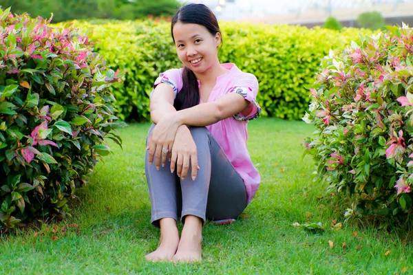 Mulher asiática sentada e sorriso — Fotografia de Stock