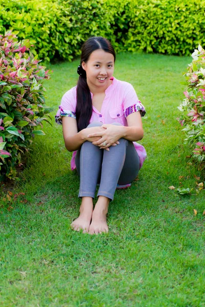 Азиатка сидит и улыбается — стоковое фото