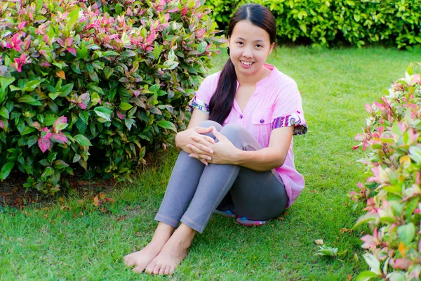 Aziatische vrouw zitten en glimlach — Stockfoto