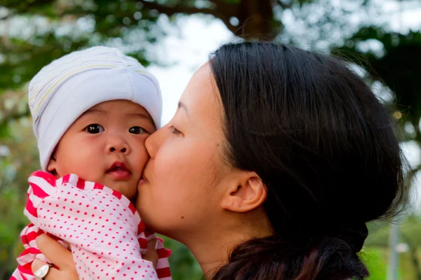 アジアの女性彼女の赤ちゃんにキスします。 — ストック写真