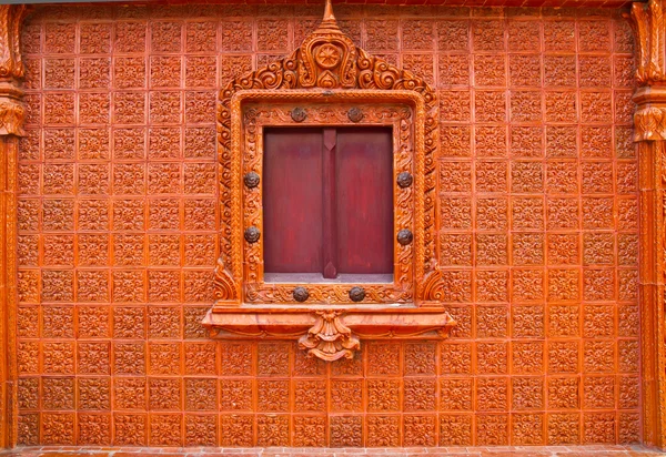 Деревянное тайское окно на коричневой стене плитки — стоковое фото