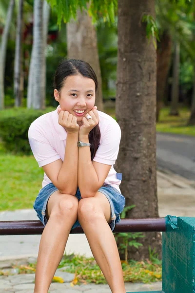 Asiatico donna seduta e sorriso su panchina — Foto Stock