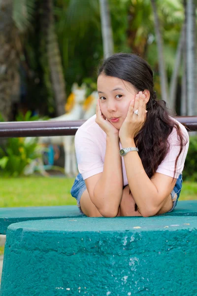 Asiatico donna seduta e sorriso su panchina — Foto Stock