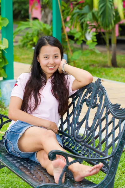 Asiática mujer sentado y sonrisa en banco —  Fotos de Stock