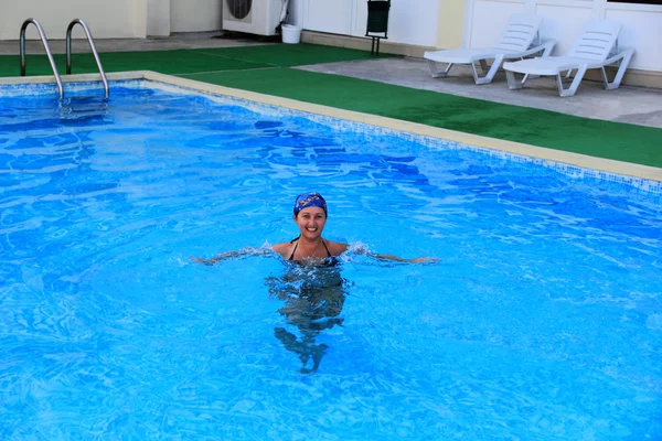 stock image Beautiful smiling girl sailling in pool in kerchief