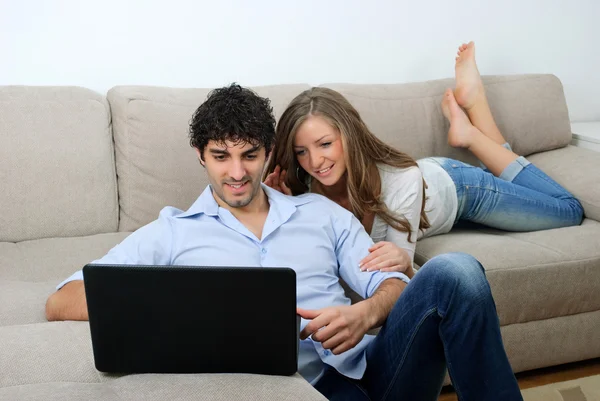 Casal jovem olhando para um laptop onde o feriado — Fotografia de Stock