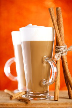 Coffee latte with cinnamon sticks, red glitter backdrop, shallow clipart