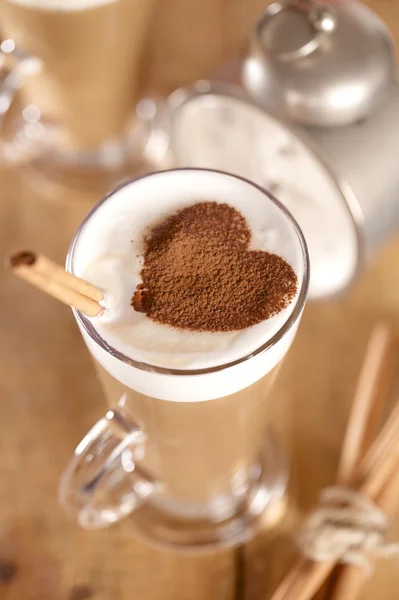 Café con leche con palitos de canela y corazón de cacao, dof poco profundo — Foto de Stock
