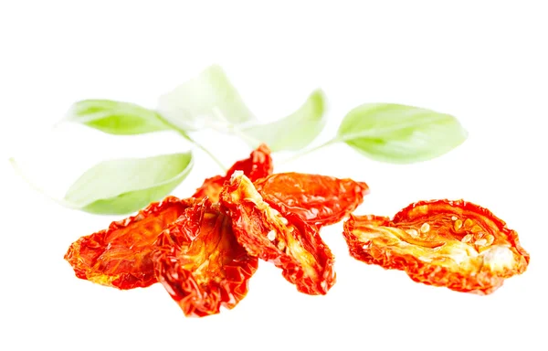 Sun-dried tomatoes with basil leaves, isolated on white — Stock Photo, Image