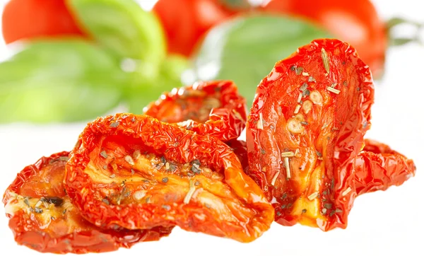 Sun-dried tomatoes with basil leaves and tomato on background, o — Stock Photo, Image