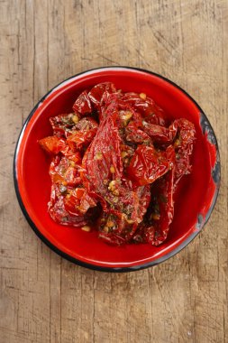 kurutulmuş domates zeytinyağı kırmızı emaye tabak, eski ahşap