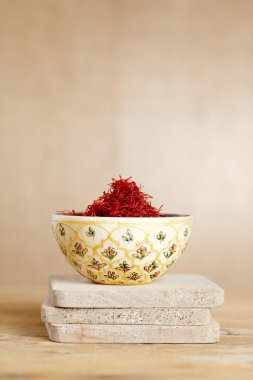 Moroccan saffron treads in bowl, on wood clipart