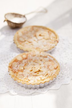 Almond tarts on wooden white table clipart