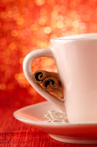 Festive cup of hot xmas drink with cinnamon sticks and golden re — Stock Photo, Image