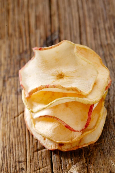 Yığılmış, sığ dof kurutulmuş elma dilimleri eski ahşap masa — Stok fotoğraf