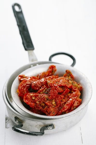 Sun-dried tomatoes with olive oil in an old tinware — Stock Photo, Image