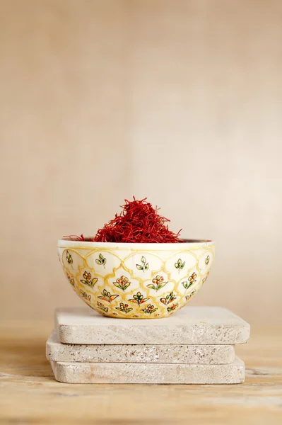 Moroccan saffron treads in bowl, on wood — Stock Photo, Image