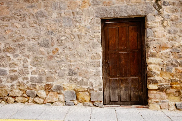 Puerta de madera muy antigua y pared de piedra —  Fotos de Stock