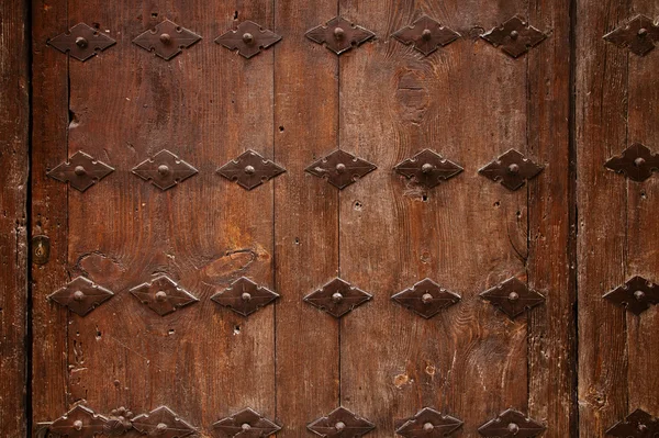 Vieja puerta de madera con fondo adornado de metal — Foto de Stock