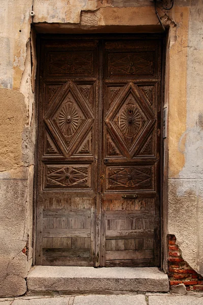 Puerta de madera muy antigua y pared de ladrillo descendente —  Fotos de Stock