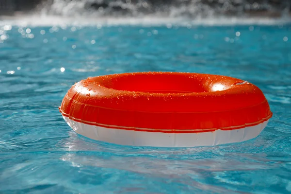 Floating ring on blue water swimpool with waves reflecting in t
