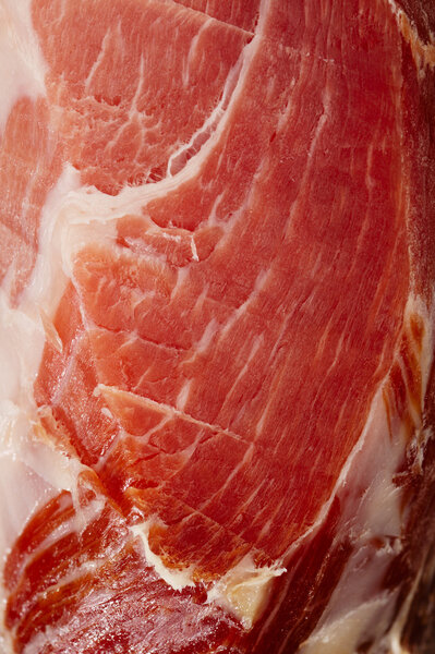 Spanish Serrano Ham Jamon sliced closeup background
