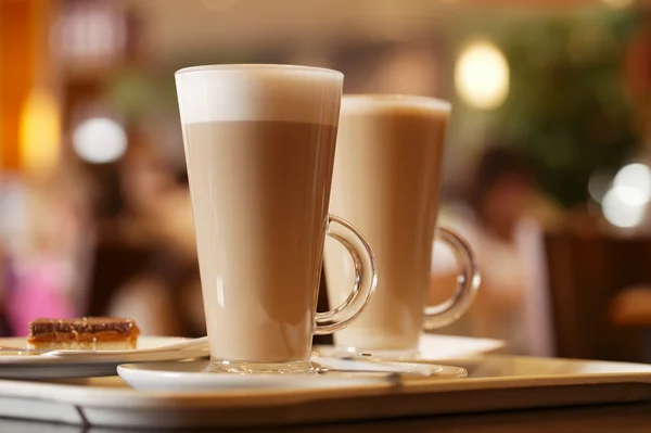 Coffee latte in two tall glasses inside — Stock Photo, Image