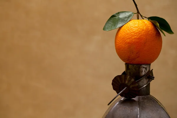 Fruit orange marocain sur une vieille lampe métallique contre un mur de couleur — Photo