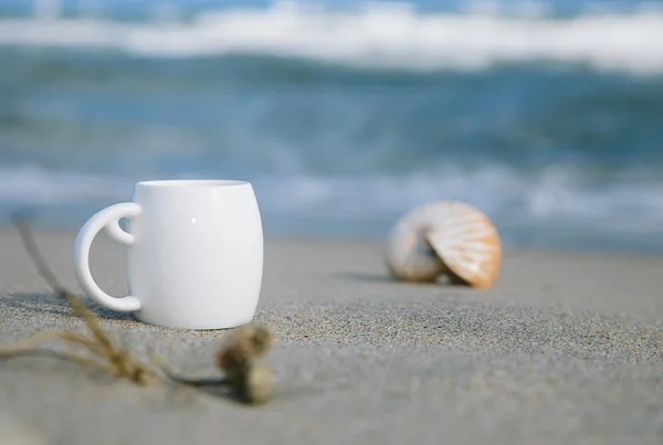 Café expreso en taza blanca con olas del océano, playa y marisco —  Fotos de Stock