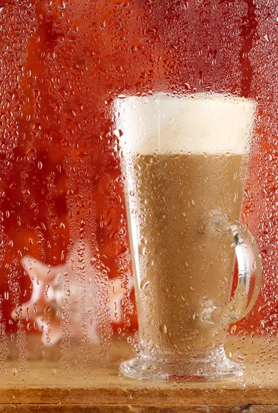Coffee latte behind rainy window, shallow dof on glass with drop — Stock Photo, Image