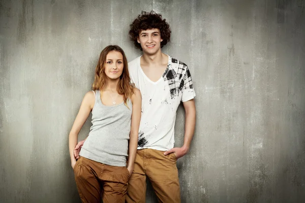 Konstnärliga porträtt av ett ungt par på en grå, textur ba — Stockfoto