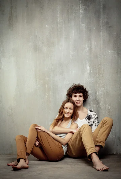 Artistic portrait of a young couple on a gray, textural backgrou — Stock Photo, Image