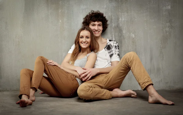 Umělecký portrét mladého páru na šedé, texturních poz — Stock fotografie